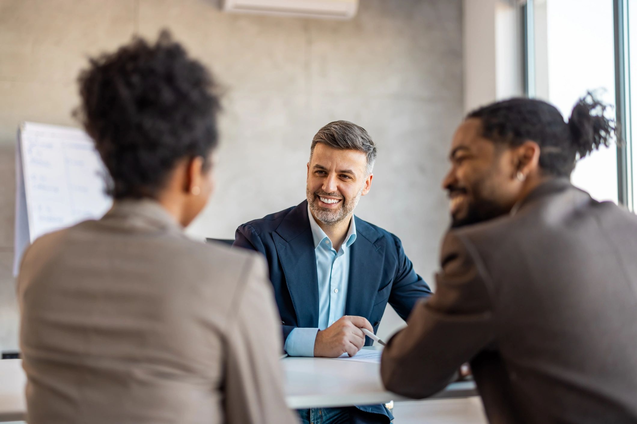 Real estate professional consulting with clients at a table